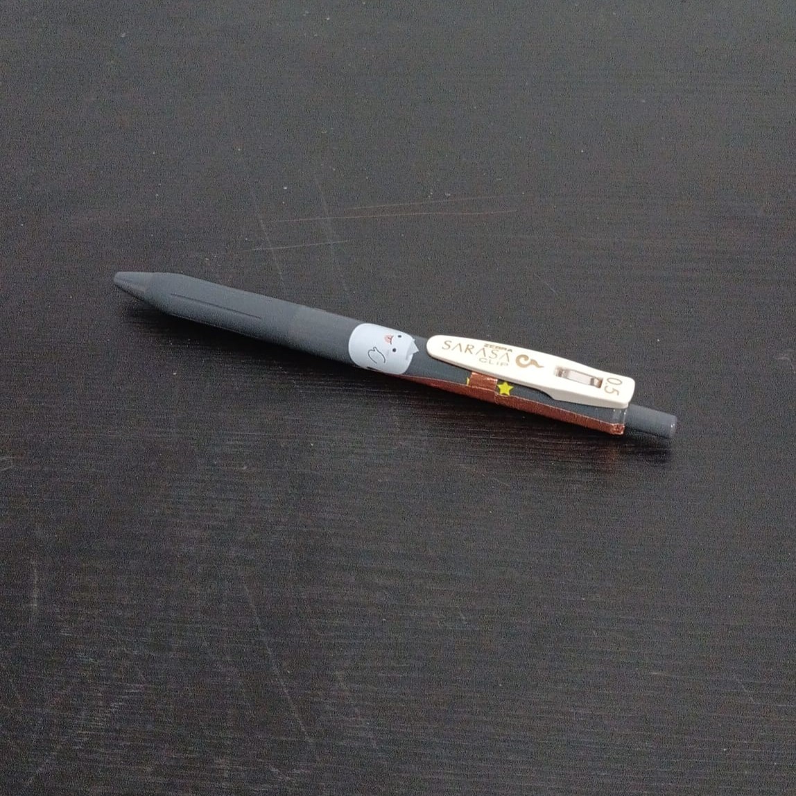 A pen placed on a surface, inviting gripping and writing movement.